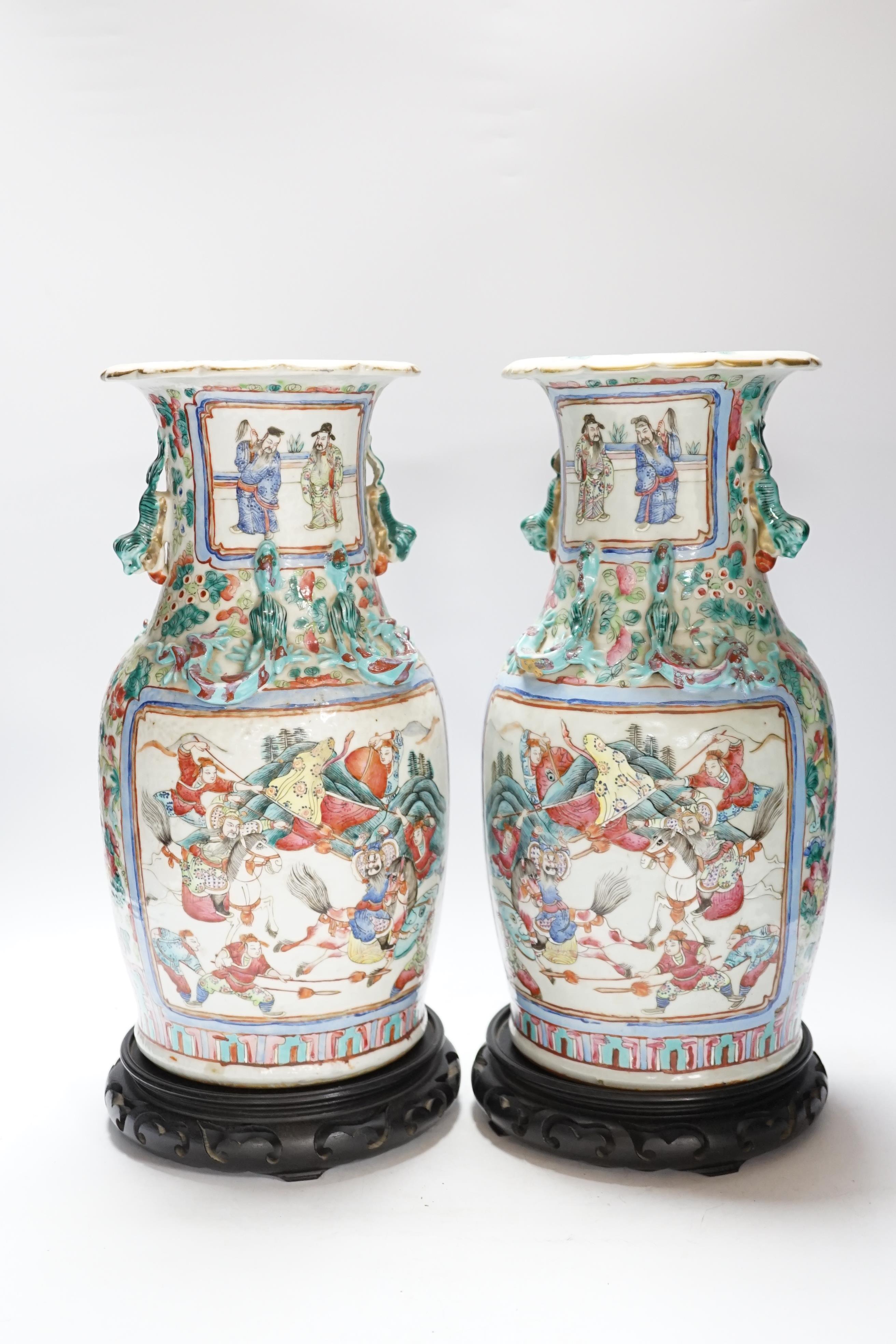 A pair 19th century Chinese famille rose ‘warriors’ baluster vases and stands, 39cm high including stands